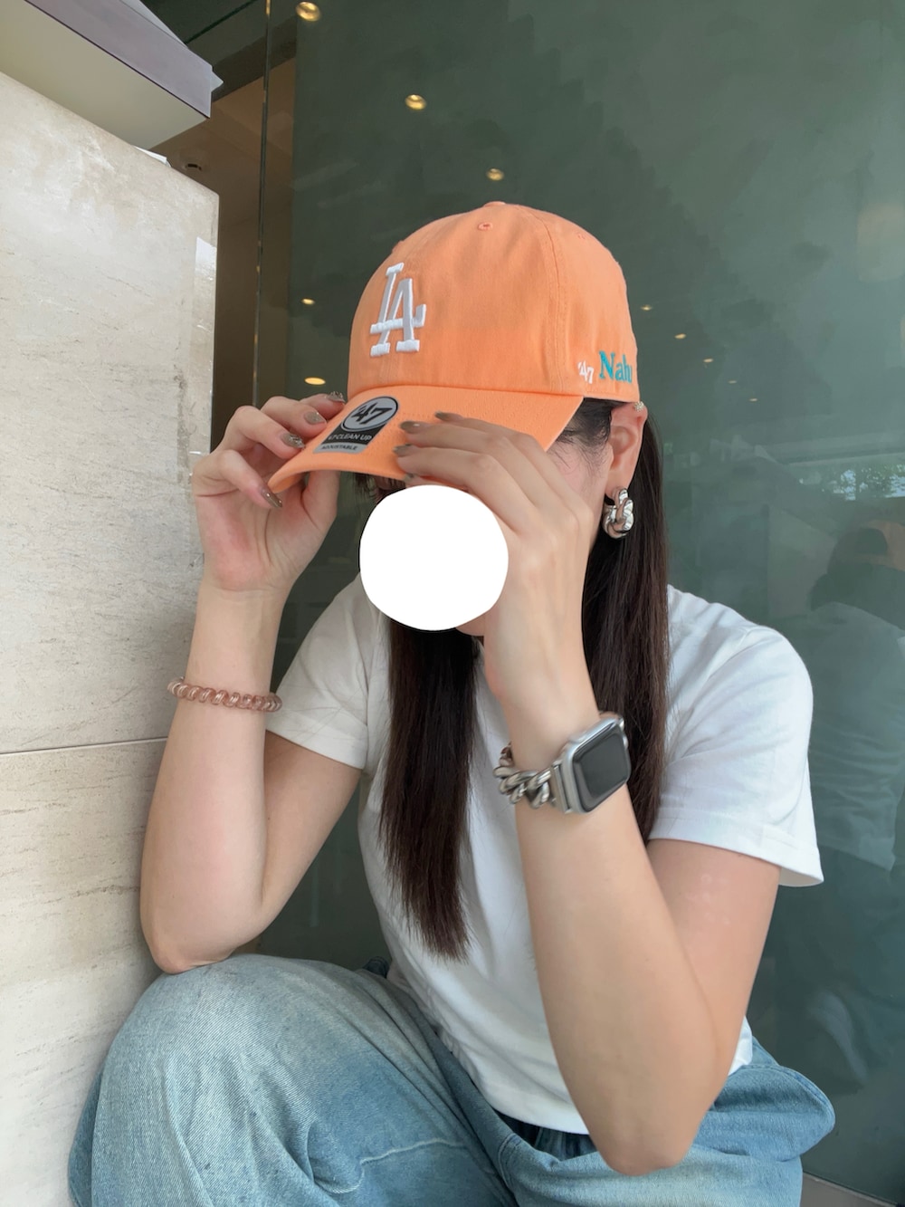 ブルー系のデニムパンツ、ホワイト系のスニーカー、ホワイト系のTシャツ/カットソーを着用したレディースの夏コーディネートの2枚目の写真