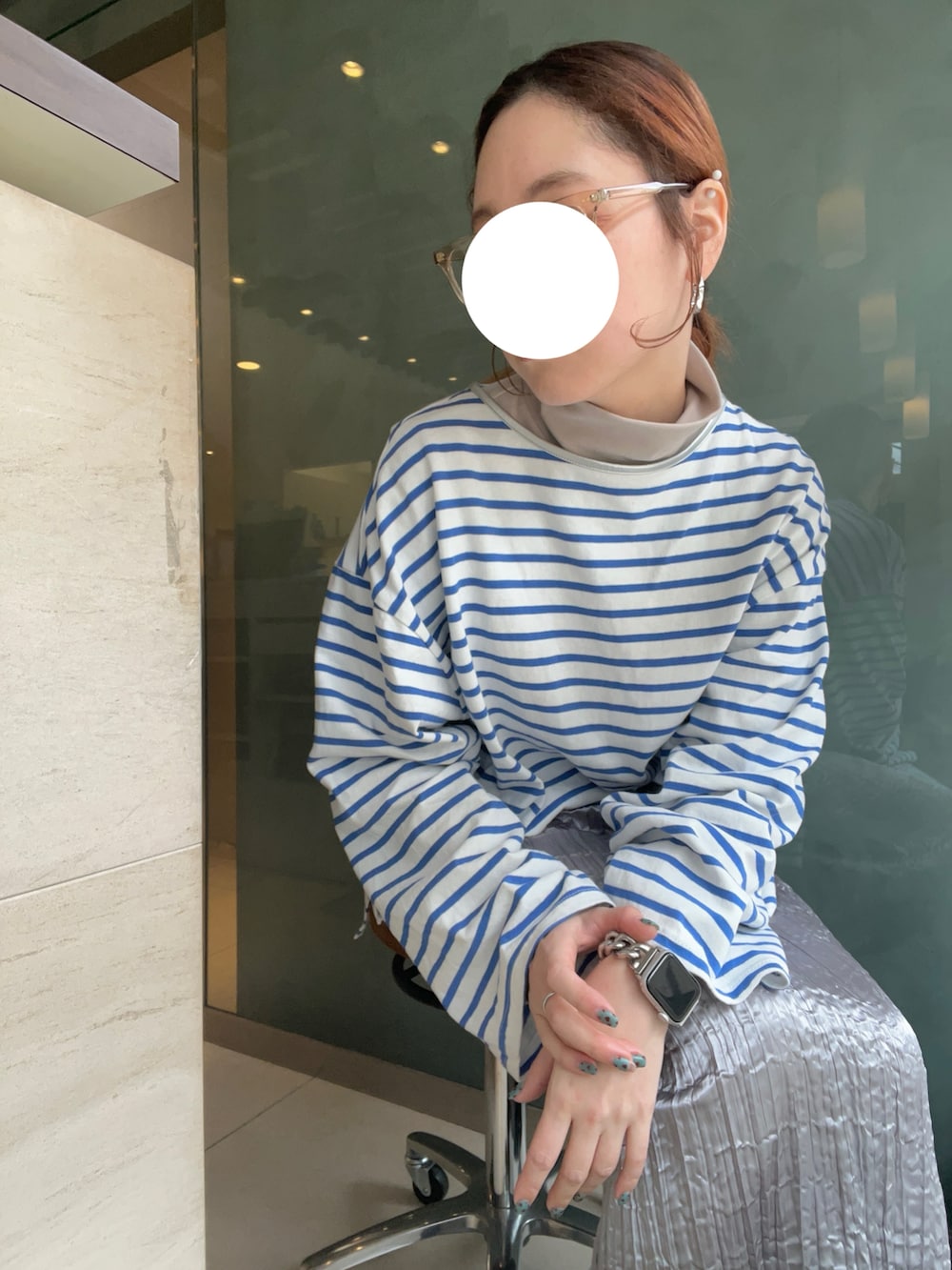 シルバー系のスカート、ブルー系のTシャツ/カットソー、ブラック系のスニーカーを着用したレディースの冬コーディネートの4枚目の写真