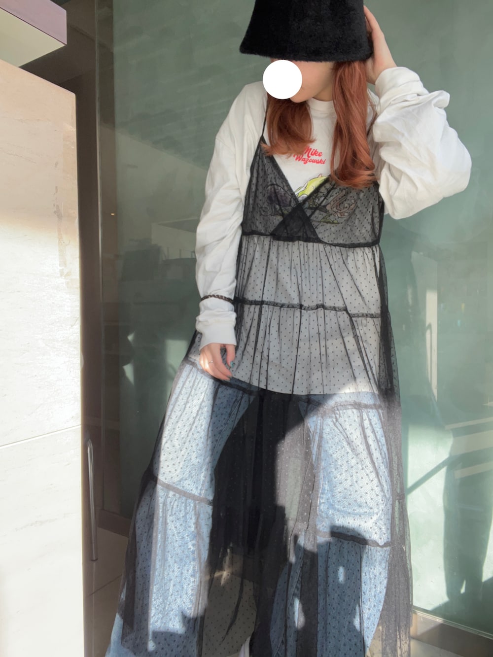 ホワイト系のTシャツ/カットソー、ブラック系のワンピース/ドレス、ブルー系のデニムパンツを着用したレディースの冬コーディネートの2枚目の写真