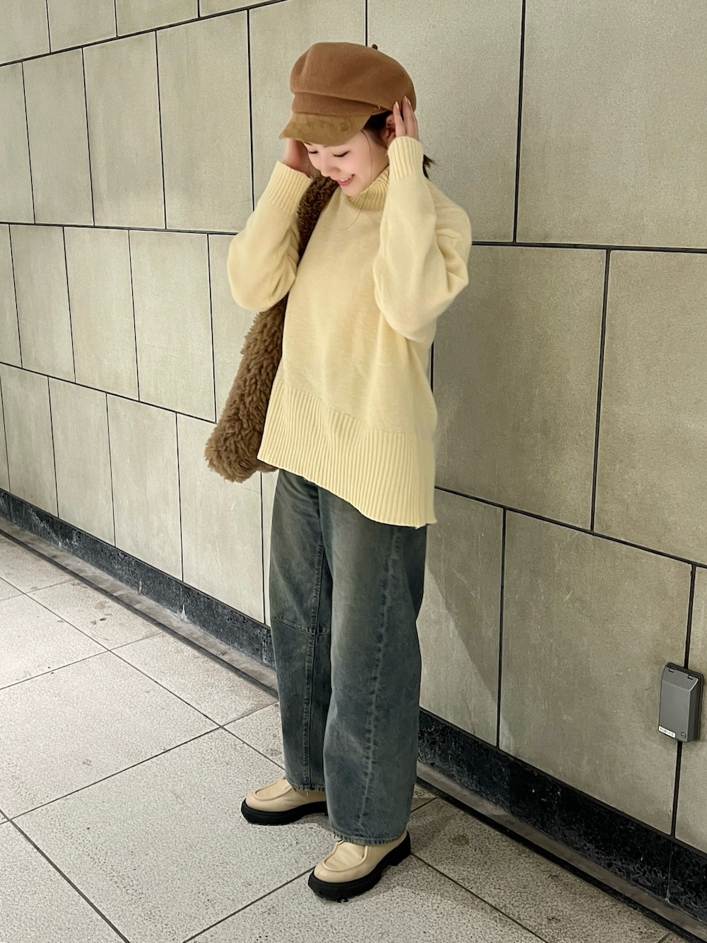 ホワイト系のニット/セーター、ブルー系のデニムパンツ、ベージュ系のモカシン/デッキシューズを着用したレディースの秋コーディネートの3枚目の写真