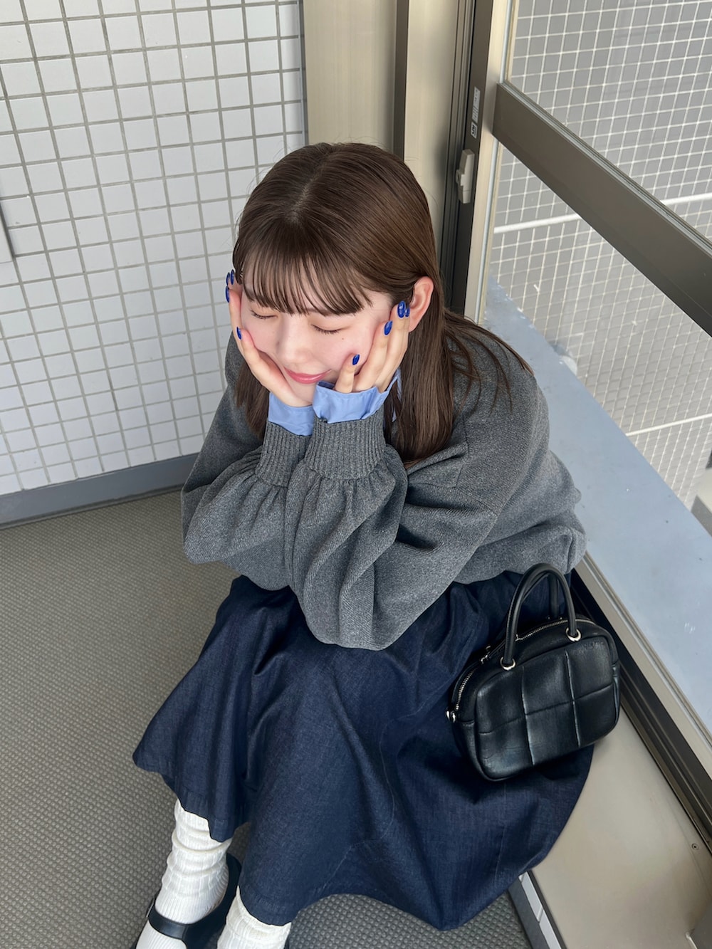 グレー系のニット/セーター、ブラック系のパンプスを着用したレディースの秋コーディネートの4枚目の写真