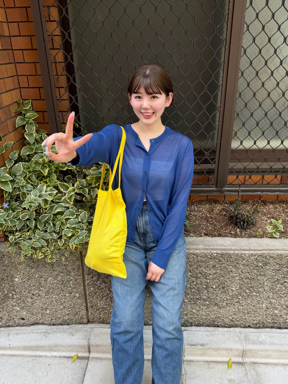 ブルー系のトップス、ブラック系のローファー、ブルー系のデニムパンツを着用したレディースの春コーディネートの3枚目の写真