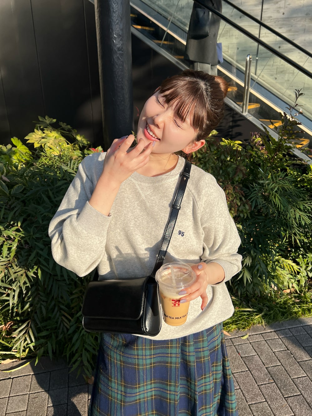 グレー系のニット/セーター、グリーン系のスカート、グレー系のスニーカーを着用したレディースの冬コーディネートの4枚目の写真