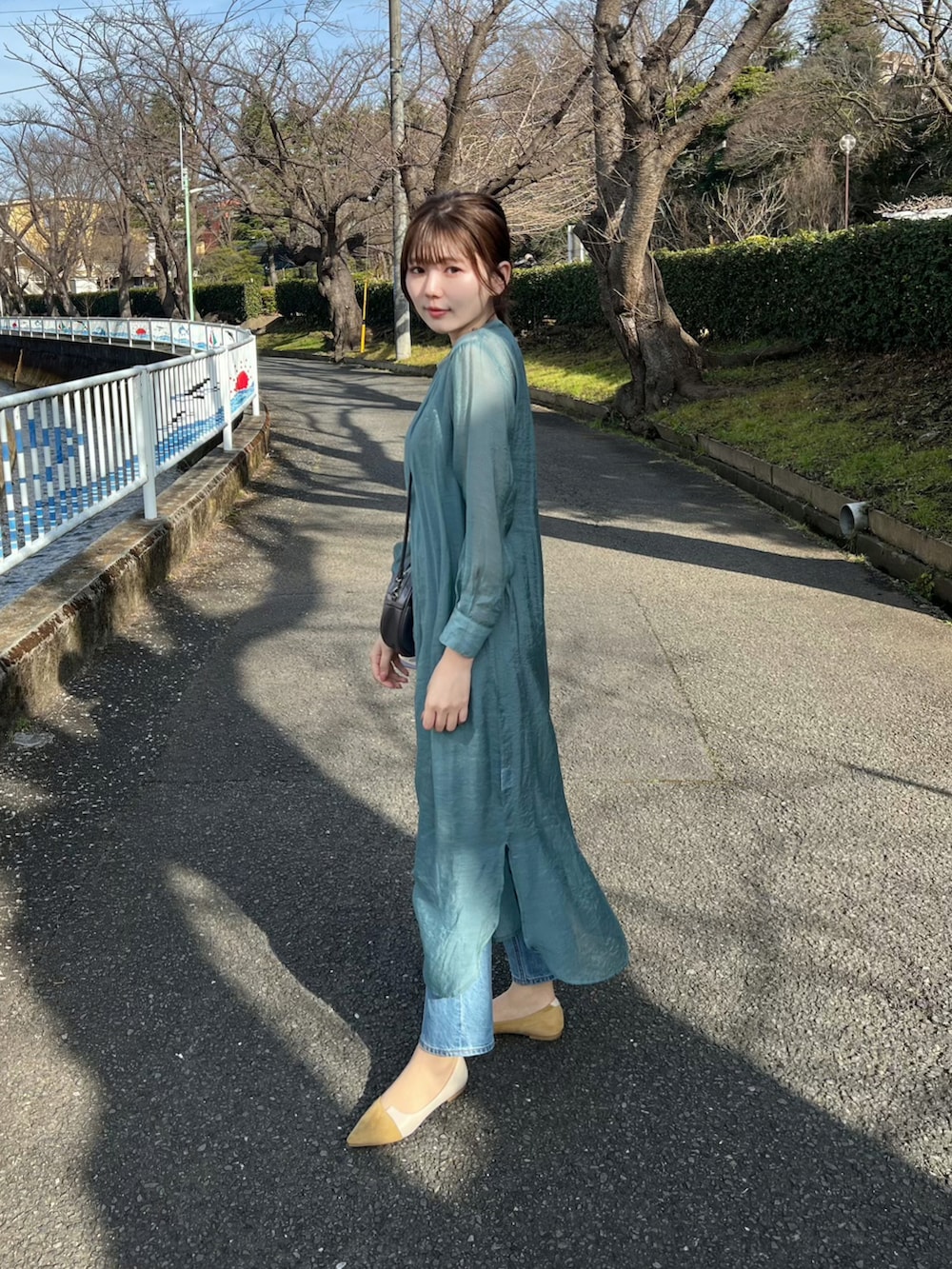 グリーン系のワンピース、グレー系のショルダーバッグ、イエロー系のパンプスを着用したレディースの春コーディネートの2枚目の写真