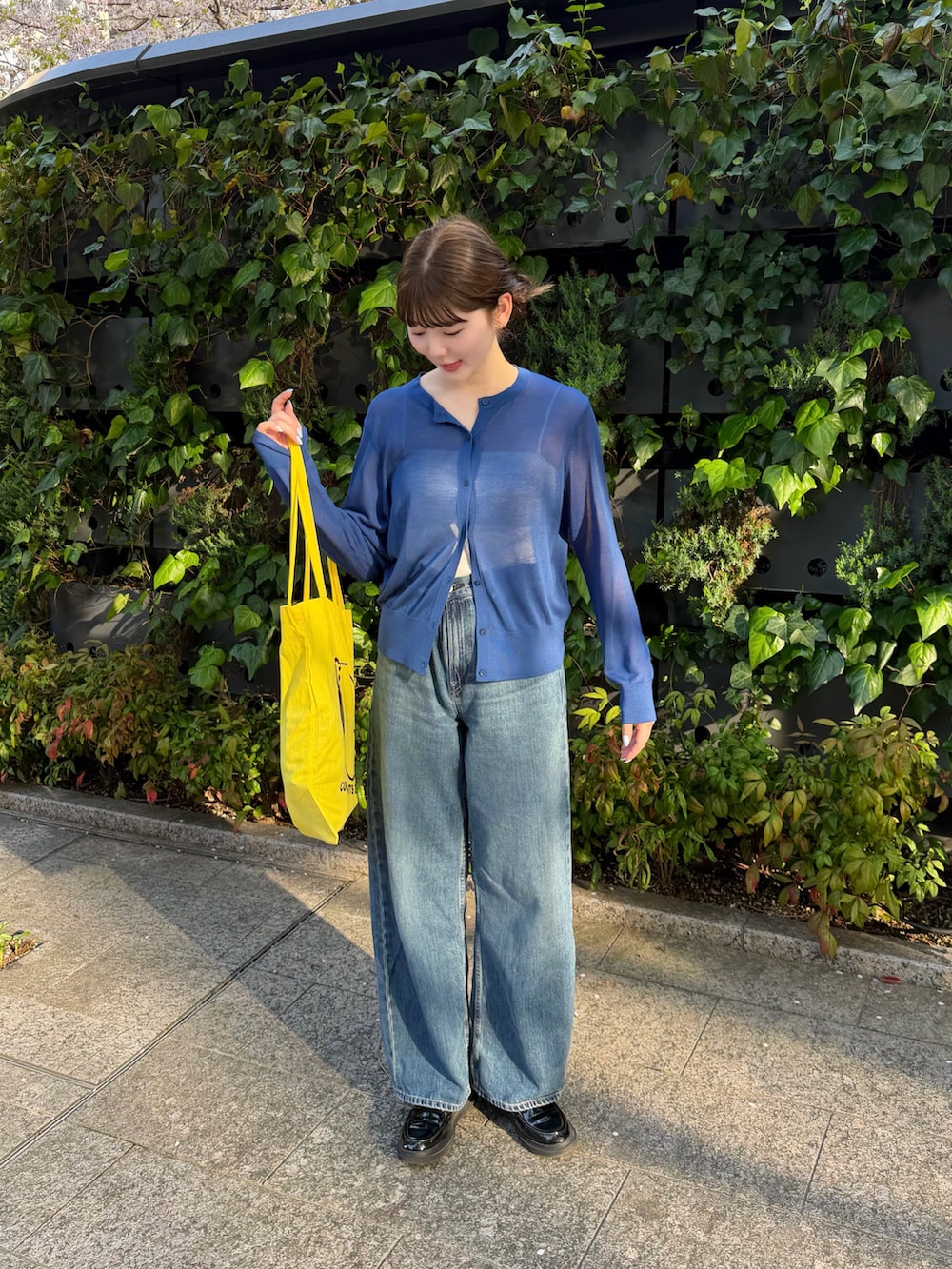 ブルー系のトップス、ブラック系のローファー、ブルー系のデニムパンツを着用したレディースの春コーディネートの5枚目の写真