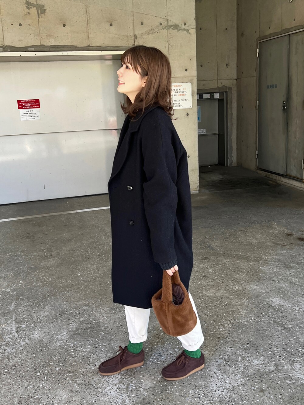 ブルー系のニット/セーター、ブラウン系のモカシン/デッキシューズ、ホワイト系のパンツを着用したレディースの冬コーディネートの2枚目の写真