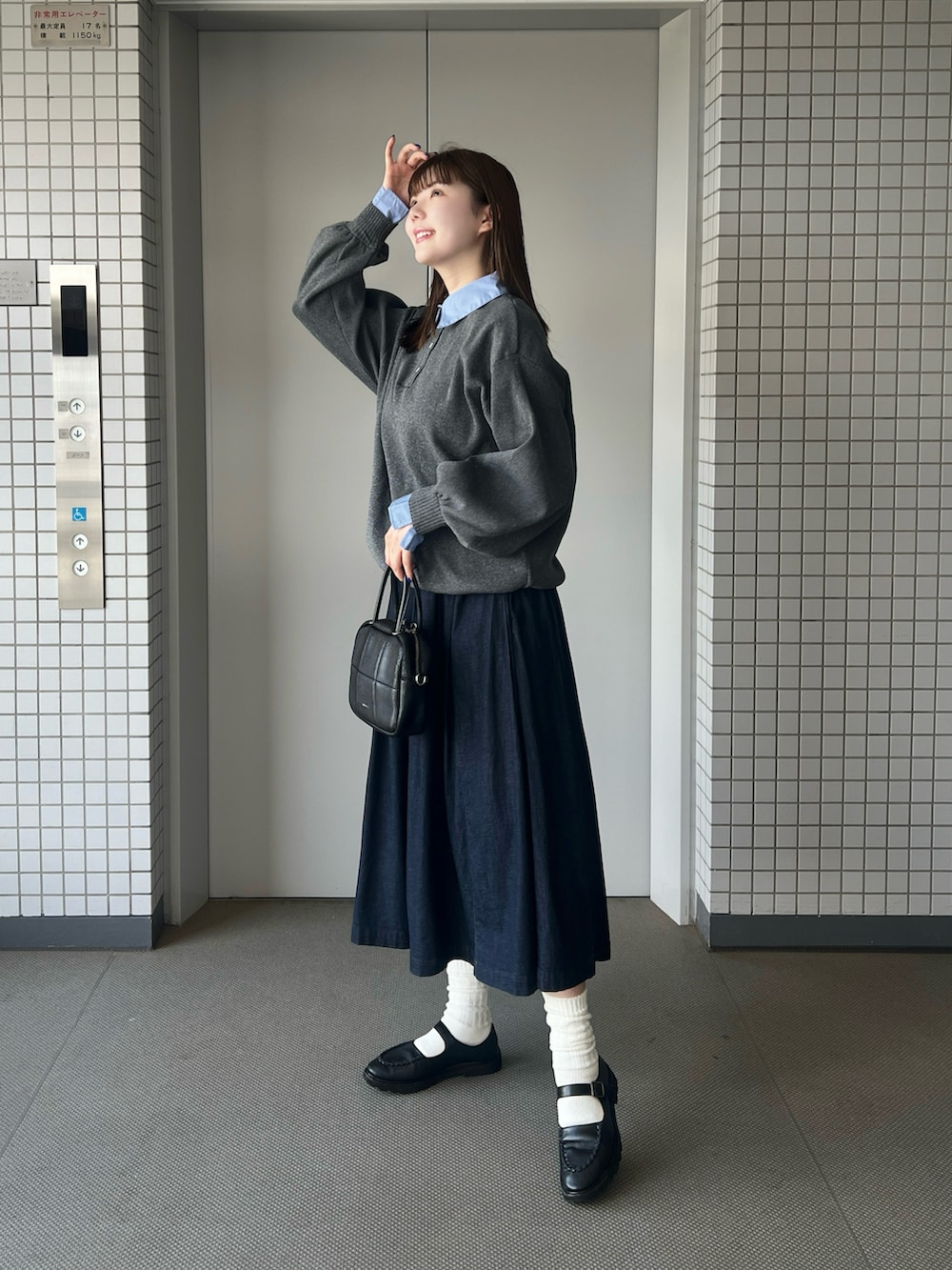 グレー系のニット/セーター、ブラック系のパンプスを着用したレディースの秋コーディネートの5枚目の写真