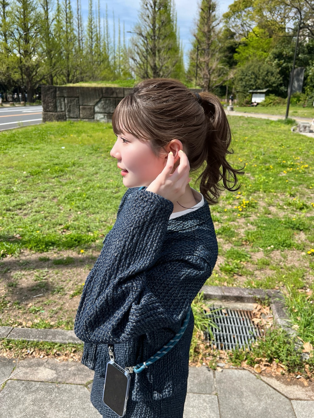 ブルー系のジャケット/アウター、ホワイト系のスニーカー、ブルー系のスマホグッズを着用したレディースの春コーディネートの3枚目の写真