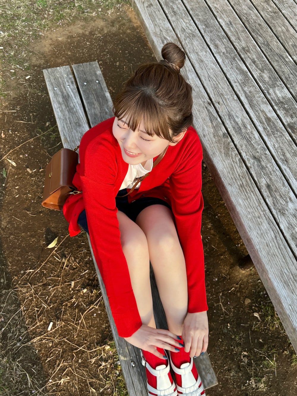 レッド系のカーディガン/ボレロ、ホワイト系のサンダルを着用したレディースの春コーディネートの4枚目の写真