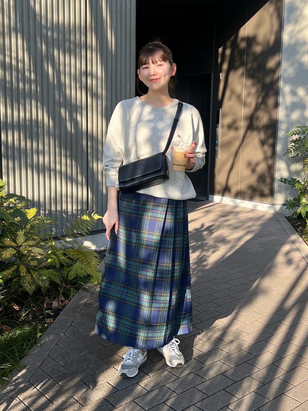 グレー系のニット/セーター、グリーン系のスカート、グレー系のスニーカーを着用したレディースの冬コーディネートの2枚目の写真