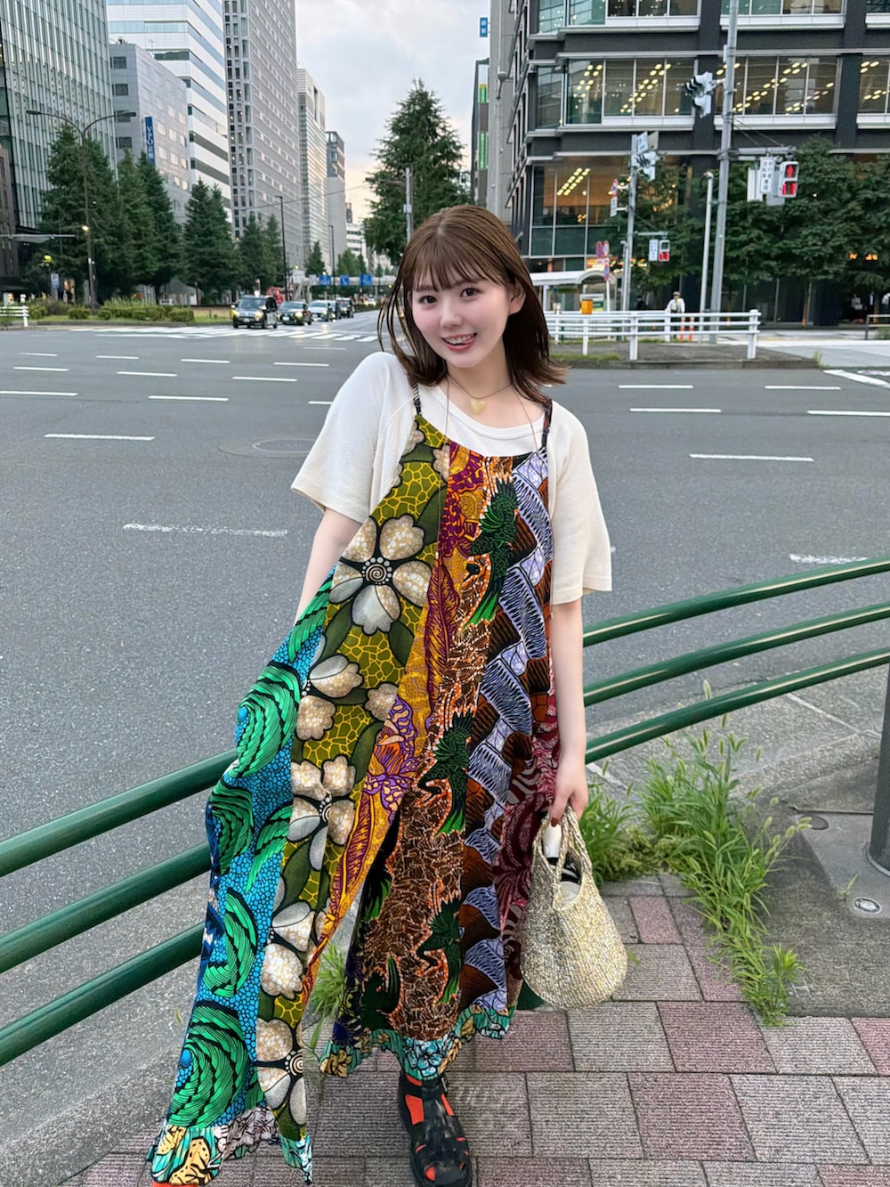 ゴールド系のかごバッグ、ブラック系のサンダルを着用したレディースの夏コーディネートの3枚目の写真