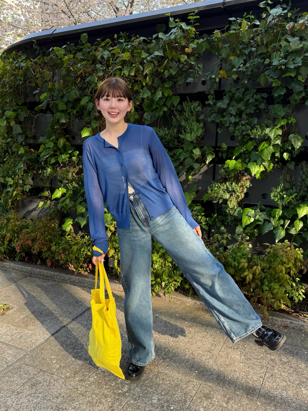 ブルー系のトップス、ブラック系のローファー、ブルー系のデニムパンツを着用したレディースの春コーディネートの2枚目の写真