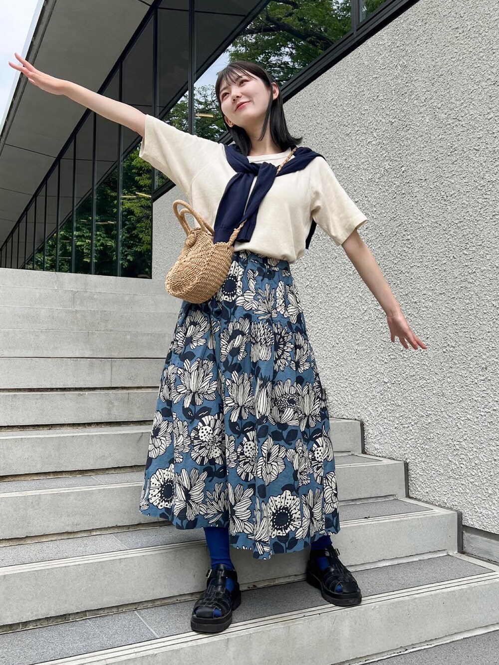 ブルー系のスカートを着用したレディースの春コーディネートの2枚目の写真