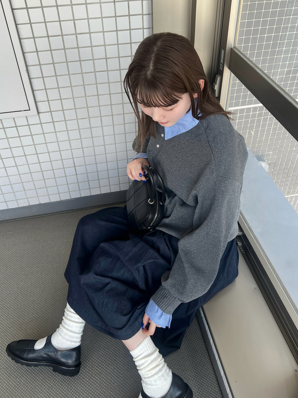 グレー系のニット/セーター、ブラック系のパンプスを着用したレディースの秋コーディネートの2枚目の写真