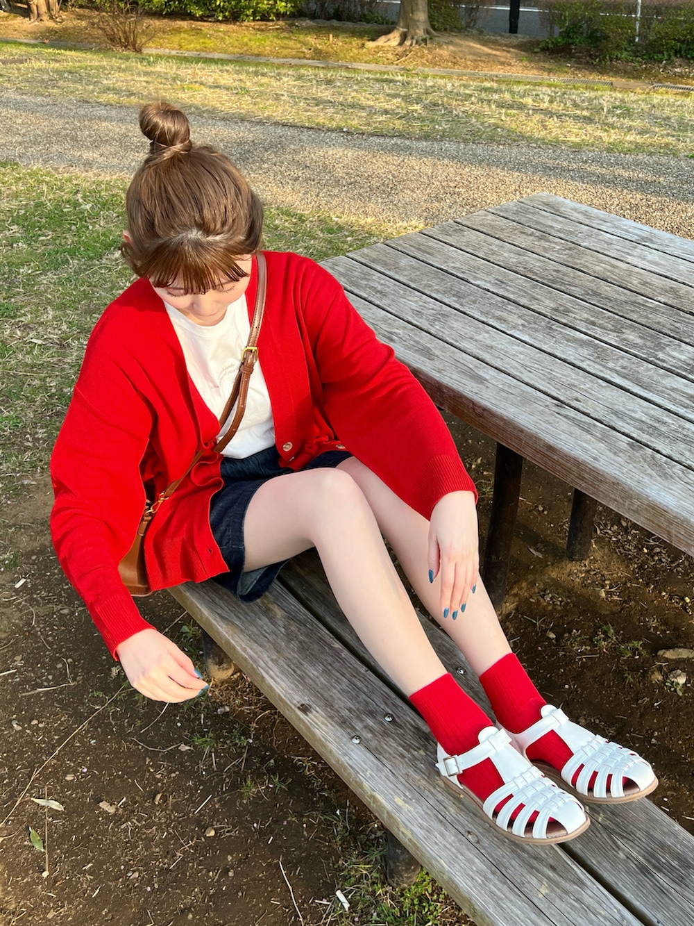 レッド系のカーディガン/ボレロ、ホワイト系のサンダルを着用したレディースの春コーディネートの3枚目の写真