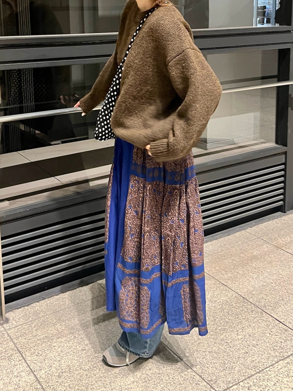 ブルー系のスカート、グレー系のスニーカーを着用したレディースの冬コーディネートの5枚目の写真