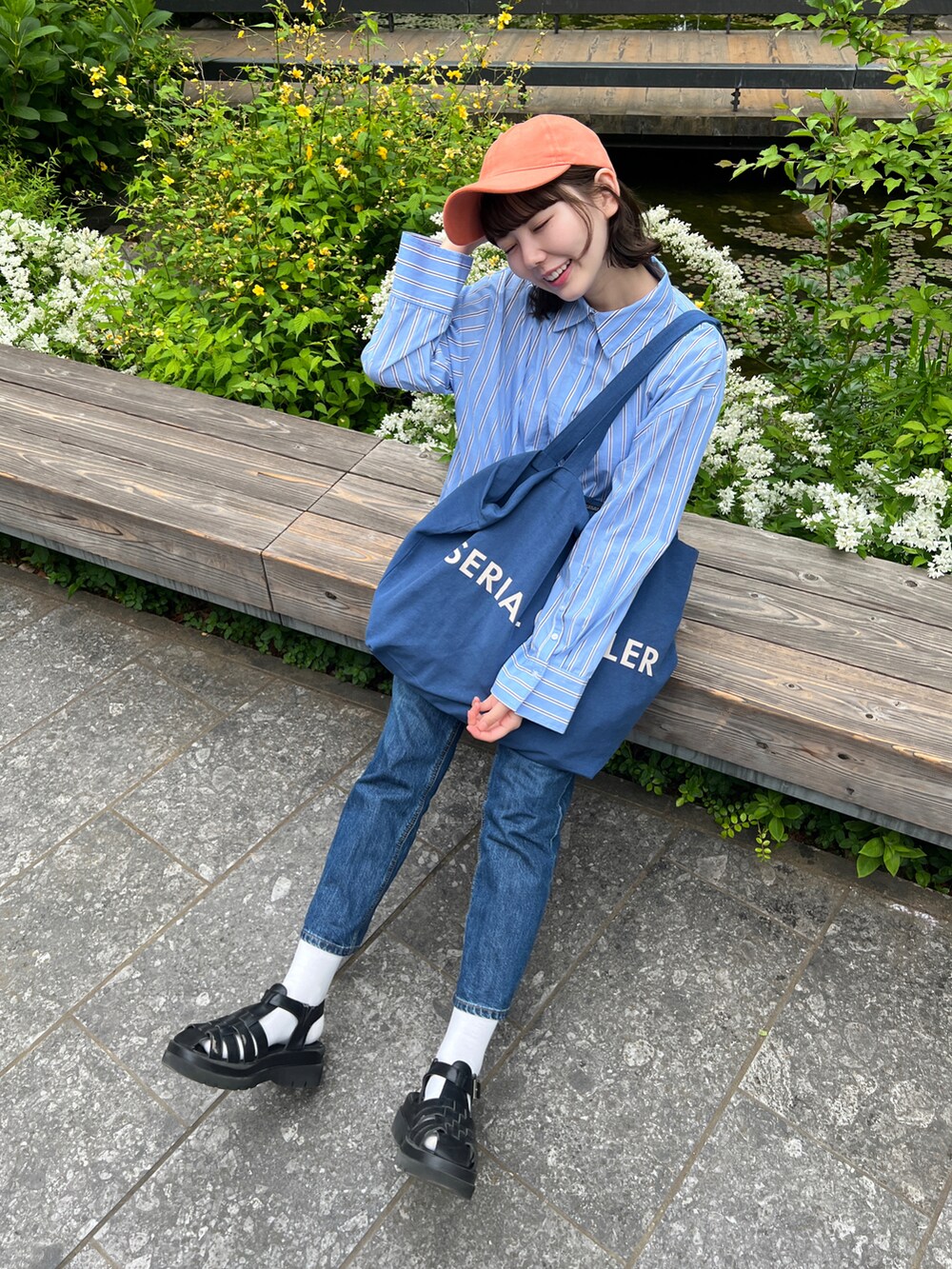 ブルー系のシャツ/ブラウス、ブラック系のサンダル、ブルー系のデニムパンツを着用したレディースの春コーディネートの2枚目の写真