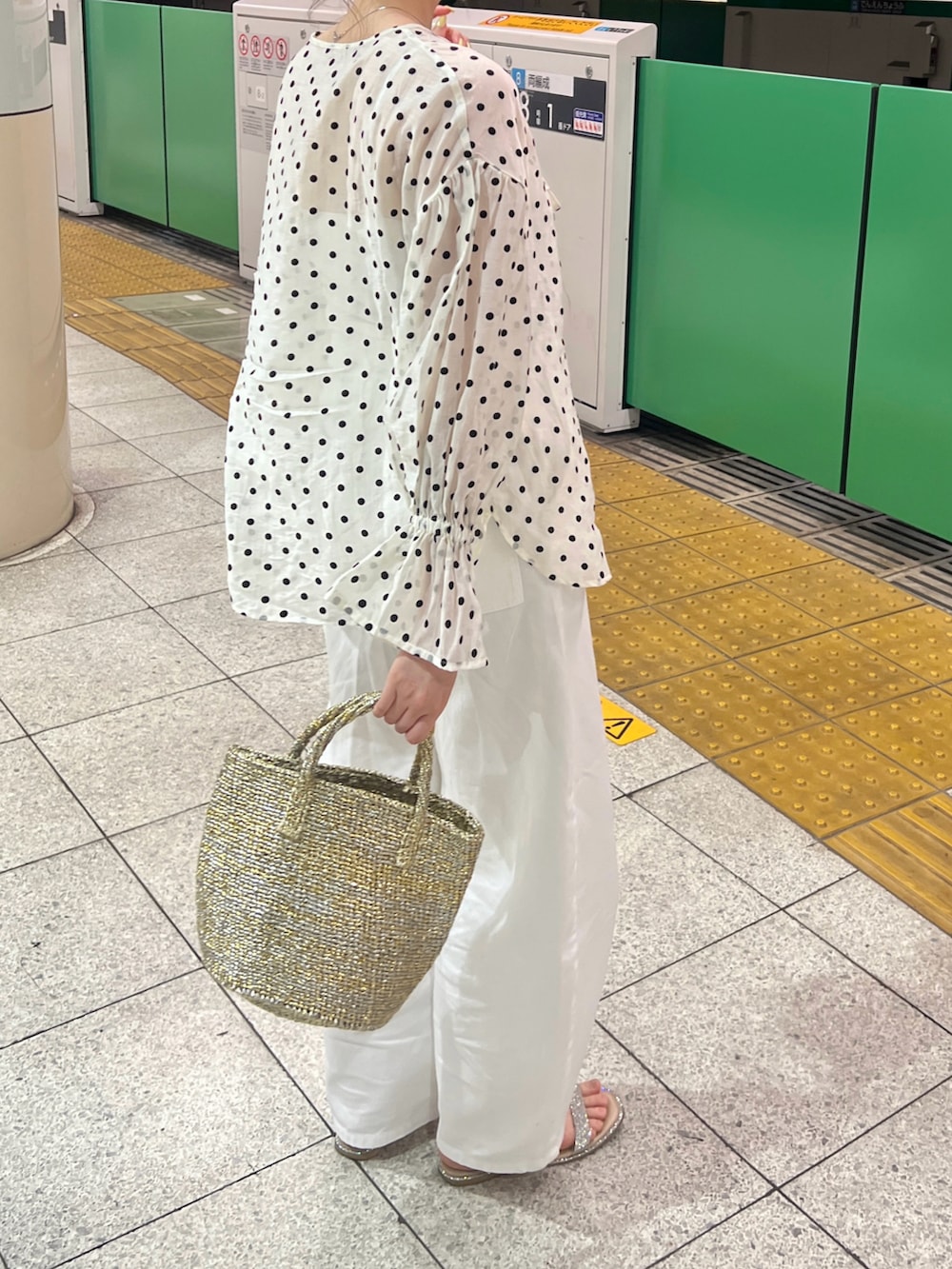 ホワイト系のシャツ/ブラウス、ゴールド系のかごバッグ、ホワイト系のデニムパンツを着用したレディースの春コーディネートの3枚目の写真