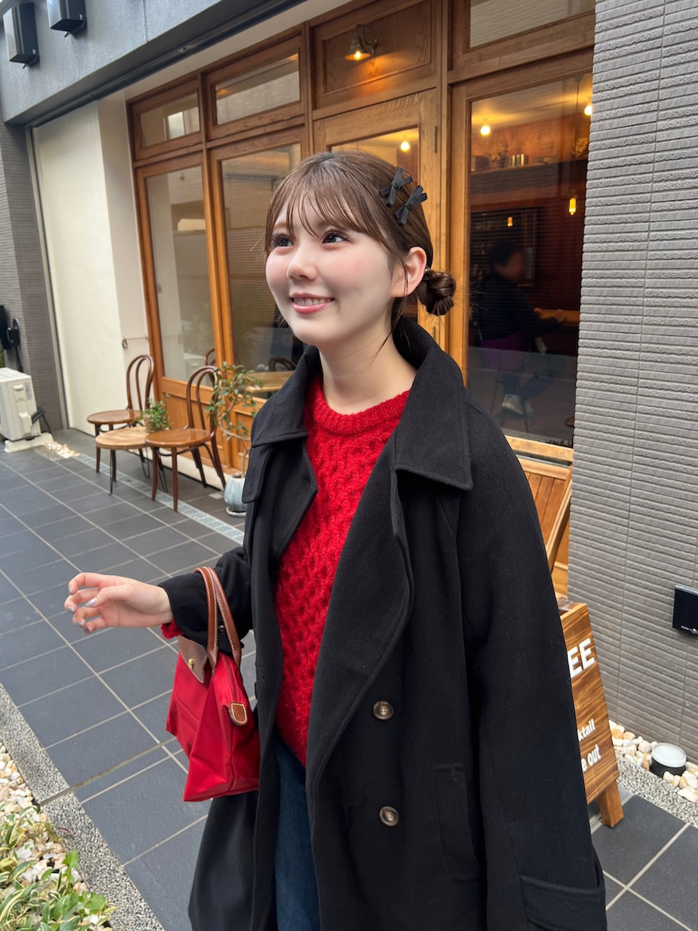 レッド系のトートバッグ、ブラック系のステンカラーコートを着用したレディースの秋コーディネートの4枚目の写真