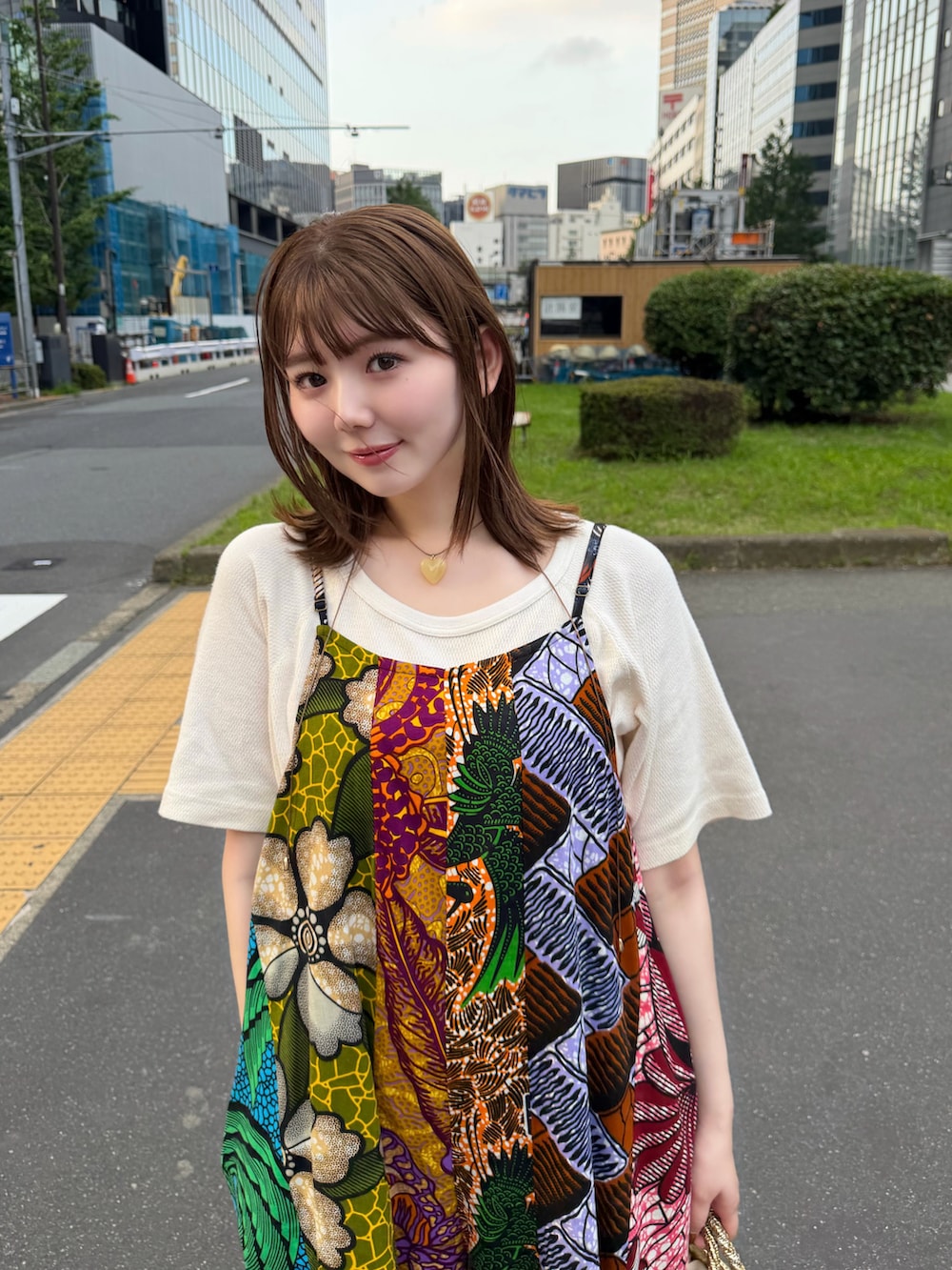 ゴールド系のかごバッグ、ブラック系のサンダルを着用したレディースの夏コーディネートの4枚目の写真