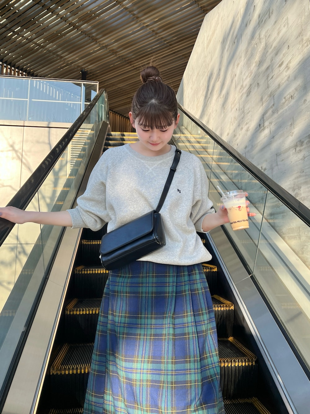 グレー系のニット/セーター、グリーン系のスカート、グレー系のスニーカーを着用したレディースの冬コーディネートの3枚目の写真