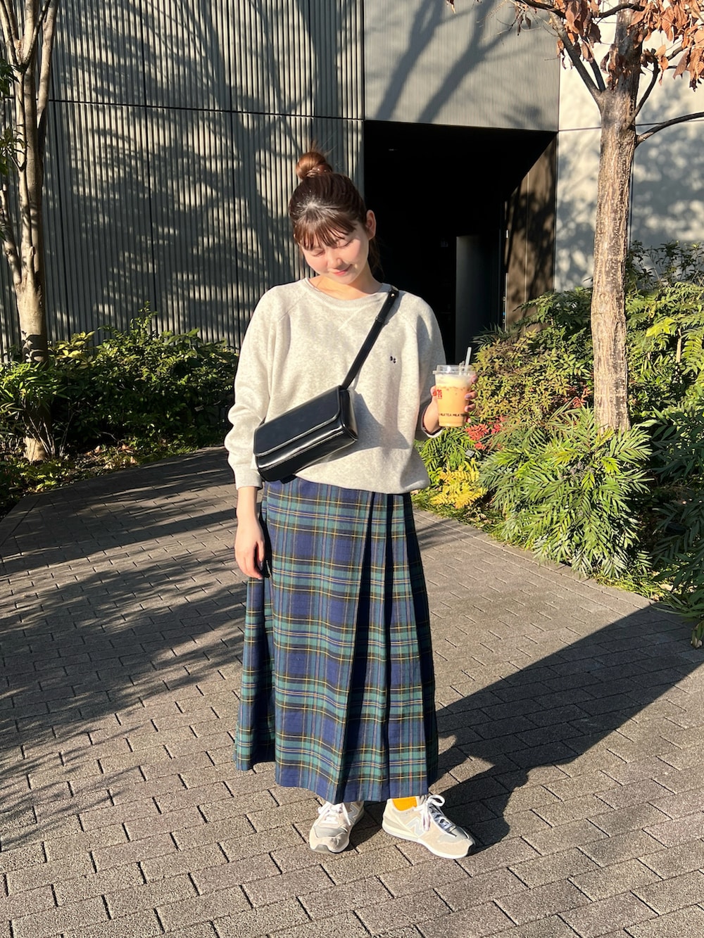 グレー系のニット/セーター、グリーン系のスカート、グレー系のスニーカーを着用したレディースの冬コーディネートの5枚目の写真