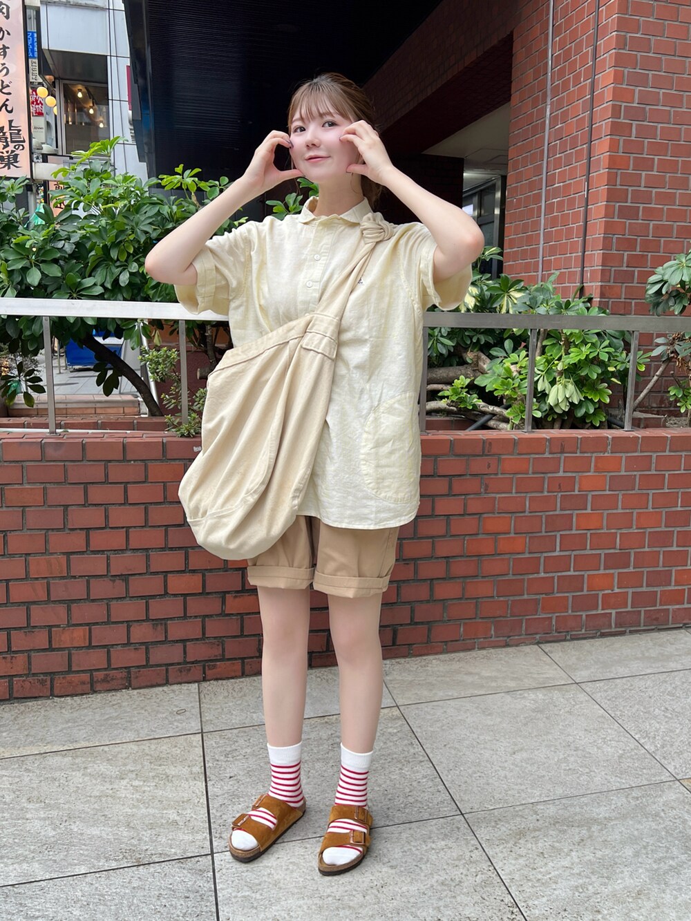 イエロー系のシャツ/ブラウス、ベージュ系のチノパンツ、イエロー系のサンダルを着用したレディースの夏コーディネートの2枚目の写真