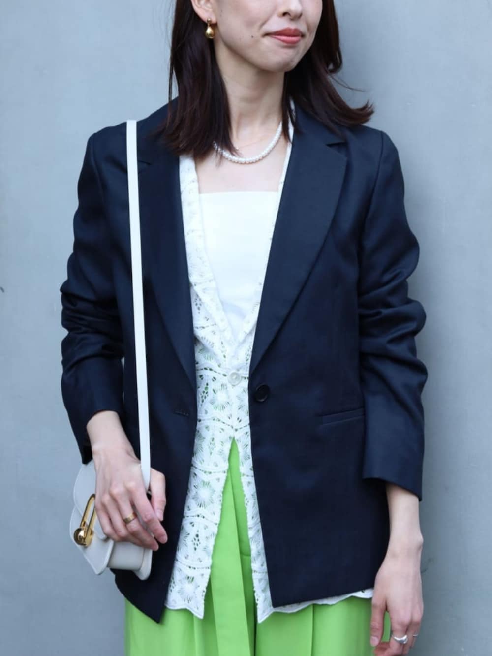 ベージュ系のショルダーバッグ、ブルー系のテーラードジャケット、ホワイト系のテーラードジャケットを着用したレディースの春コーディネートの2枚目の写真