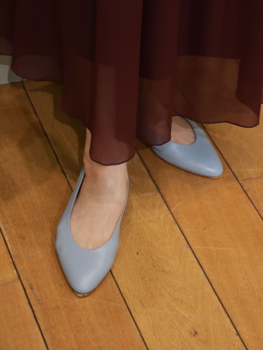 ブルー系のカーディガン/ボレロ、ブルー系のニット/セーター、レッド系のスカートを着用したレディースの夏コーディネートの6枚目の写真