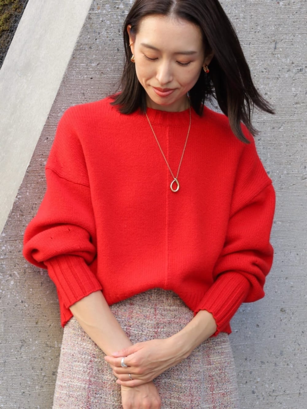 レッド系のニット/セーター、イエロー系のハンドバッグ、ベージュ系のその他シューズを着用したレディースの秋コーディネートの2枚目の写真