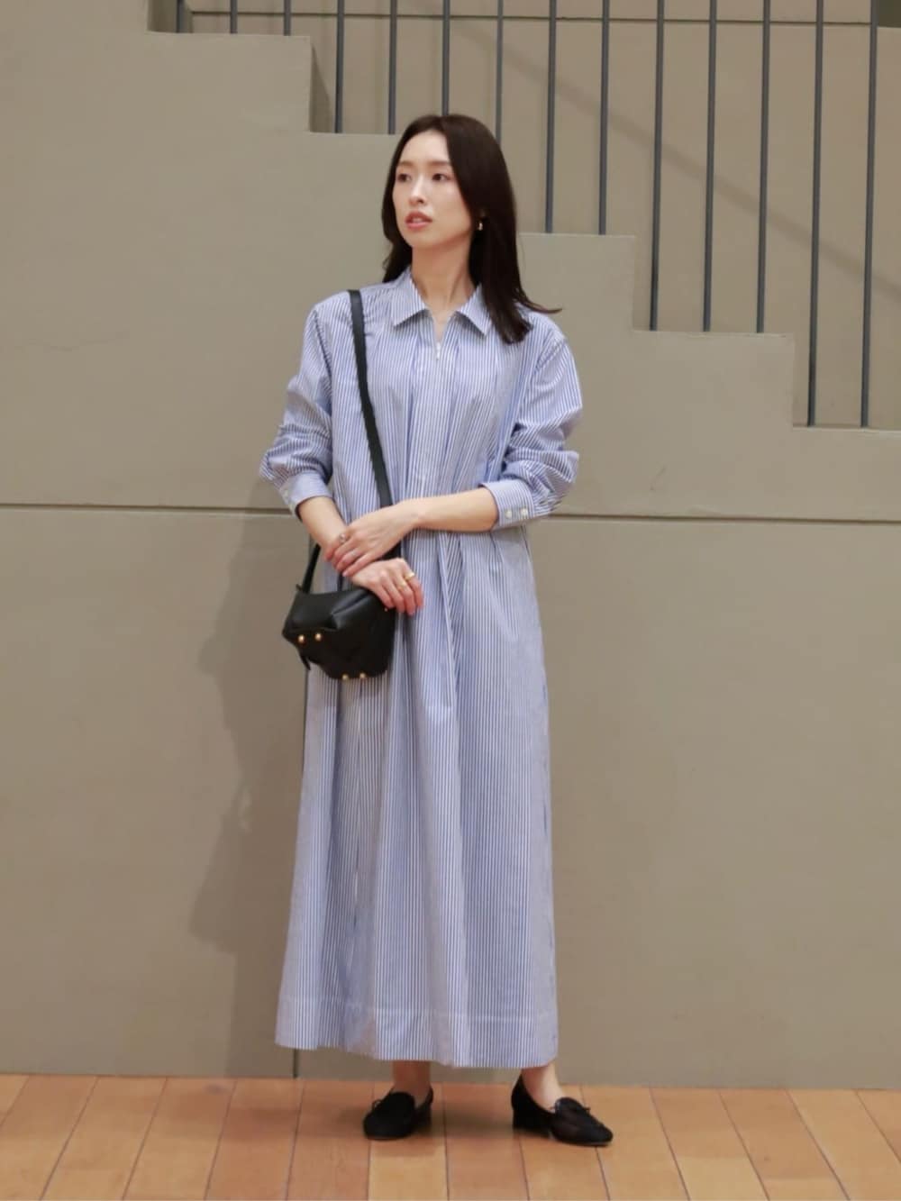 ブラック系のカーディガン/ボレロ、ブルー系のシャツワンピース、ブラック系のハンドバッグを着用したレディースの春コーディネートの3枚目の写真