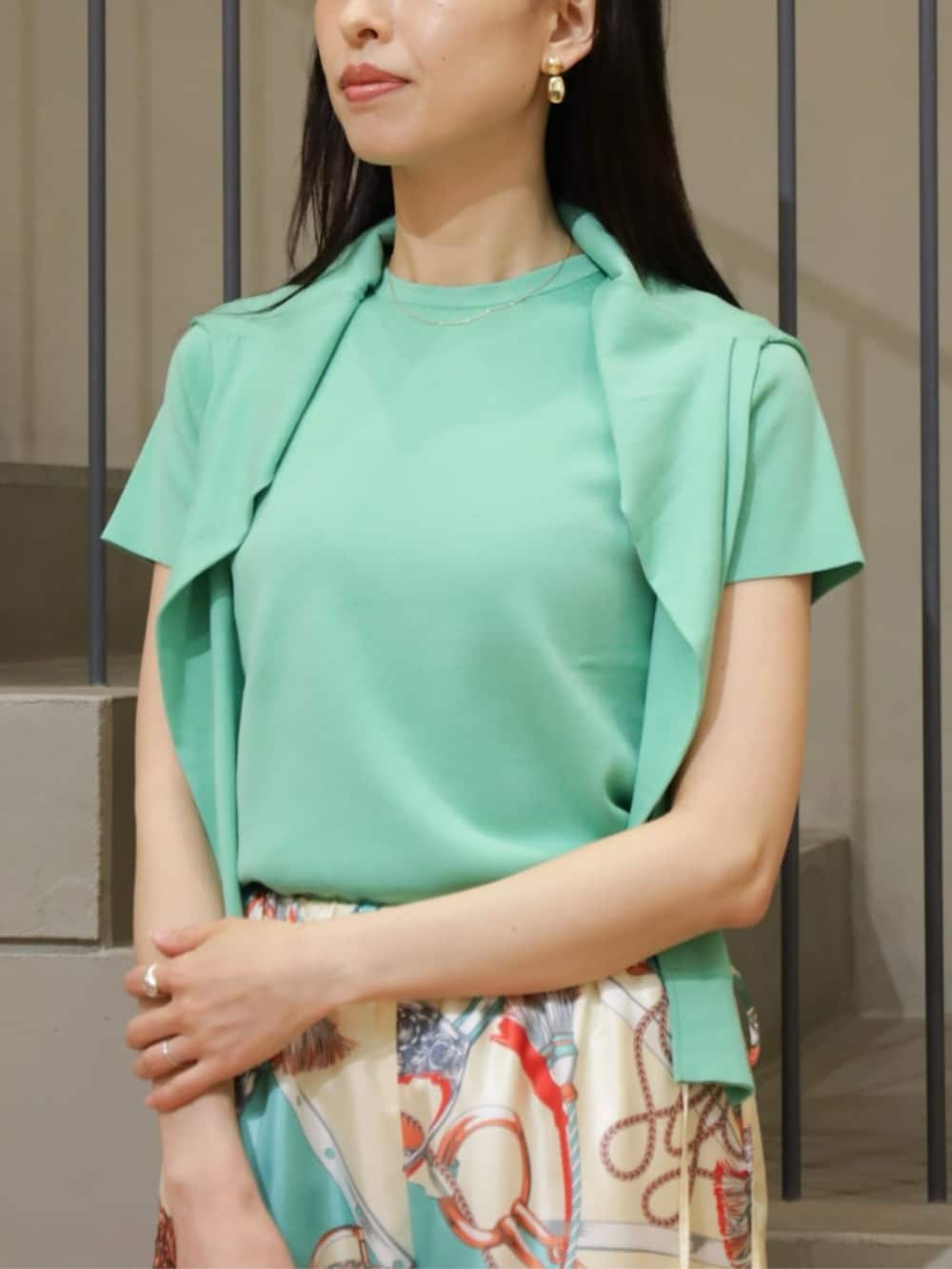 グリーン系のカーディガン/ボレロ、グリーン系のニット/セーター、グレー系のハンドバッグを着用したレディースの春コーディネートの2枚目の写真