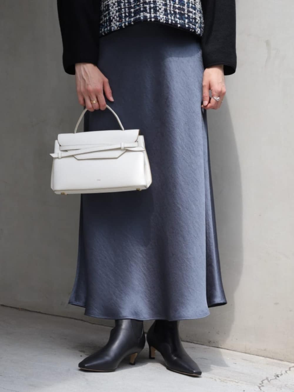 ブラック系のその他トップス、ブラック系のブーツ、ホワイト系のハンドバッグを着用したレディースの秋コーディネートの3枚目の写真