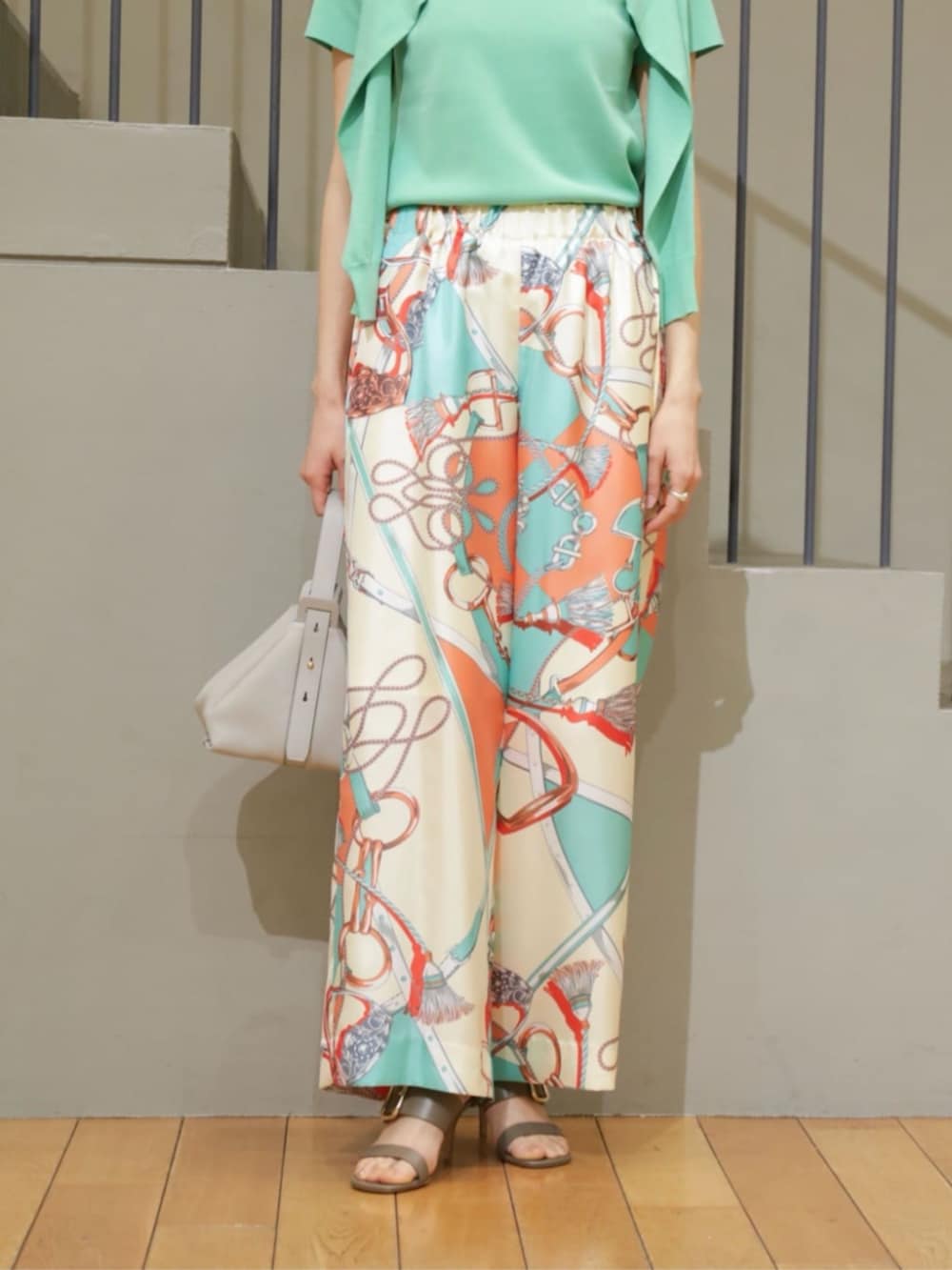 グリーン系のカーディガン/ボレロ、グリーン系のニット/セーター、グレー系のハンドバッグを着用したレディースの春コーディネートの3枚目の写真