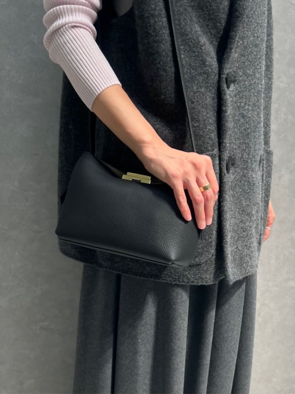 グレー系のベスト、ピンク系のニット/セーター、グレー系のスカートを着用したレディースの秋コーディネートの4枚目の写真