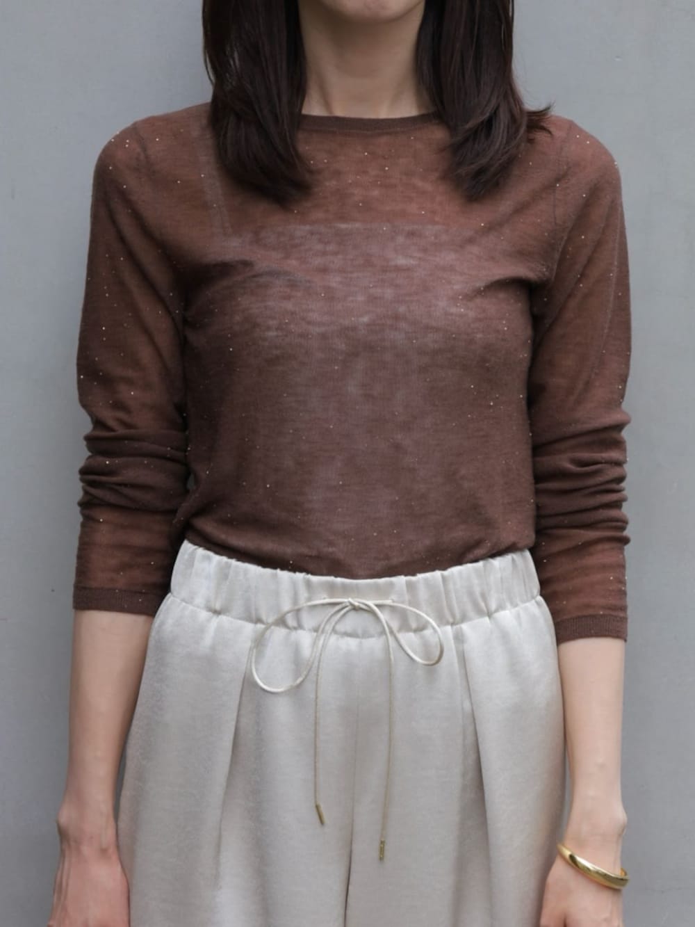 ベージュ系のその他アウター、グレー系のニット/セーター、ホワイト系のクラッチバッグを着用したレディースの秋コーディネートの3枚目の写真