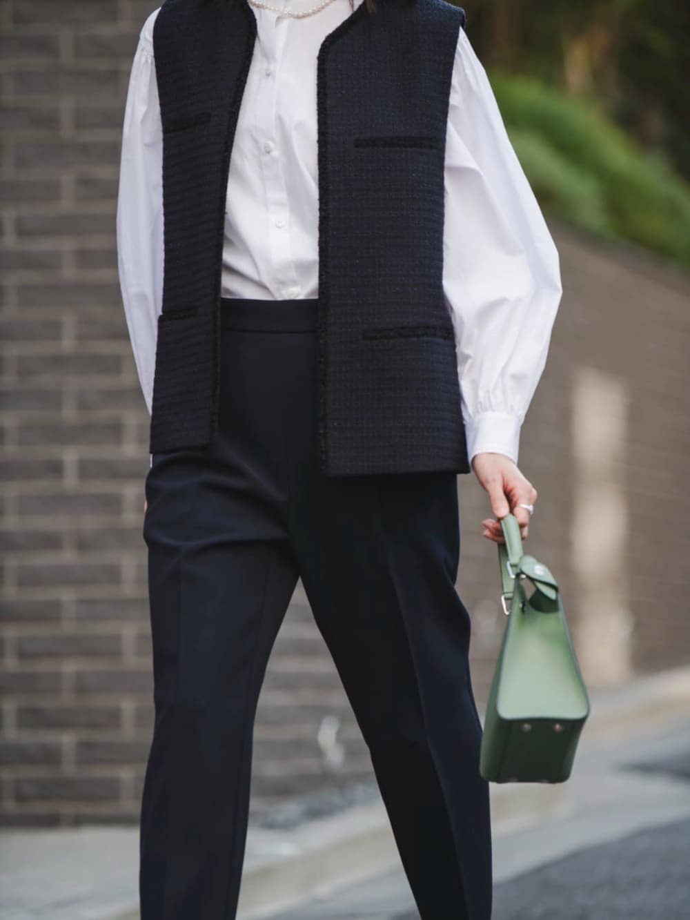 ブラック系のパンプス、ブルー系のベストを着用したレディースの冬コーディネートの3枚目の写真