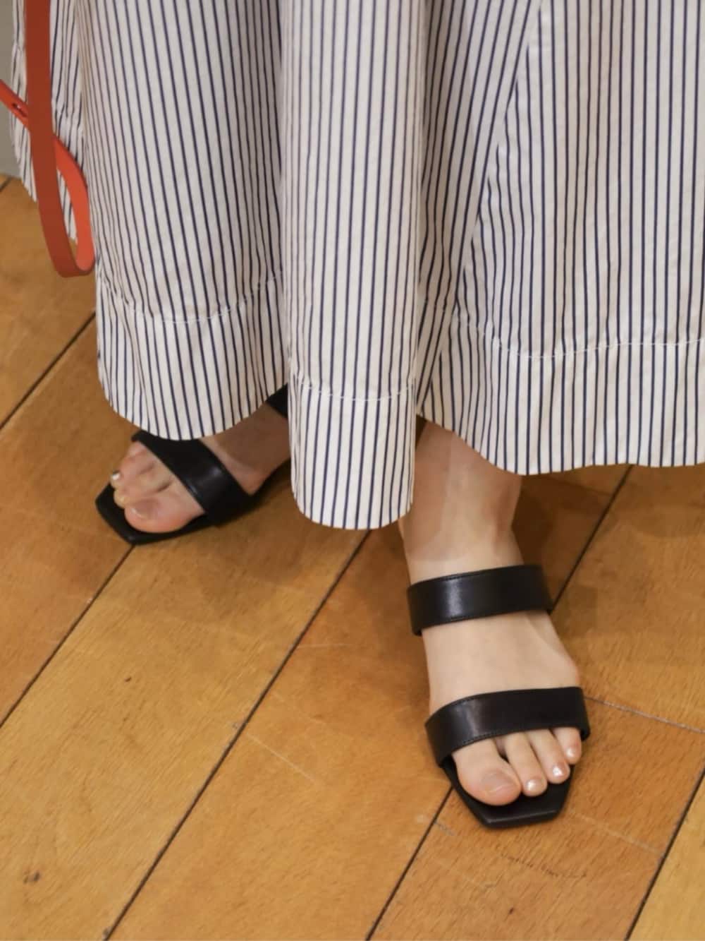 ブラック系のカーディガン/ボレロ、ブルー系のワンピース、ゴールド系のピアス(両耳用)を着用したレディースの春コーディネートの6枚目の写真