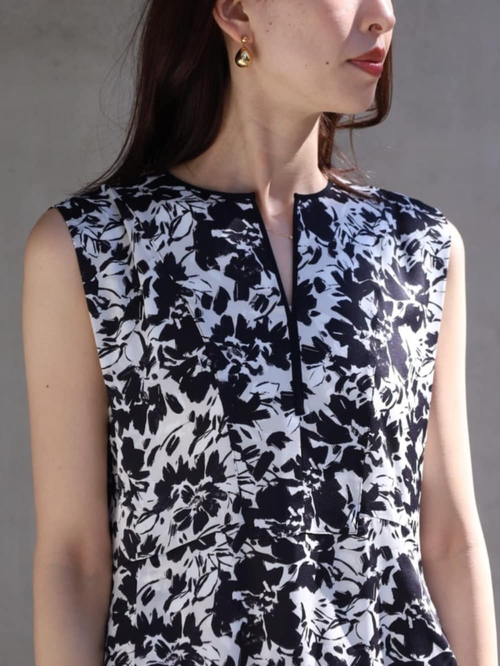 ブラック系のワンピース、ブルー系のノーカラージャケット、イエロー系のサンダルを着用したレディースの春コーディネートの3枚目の写真