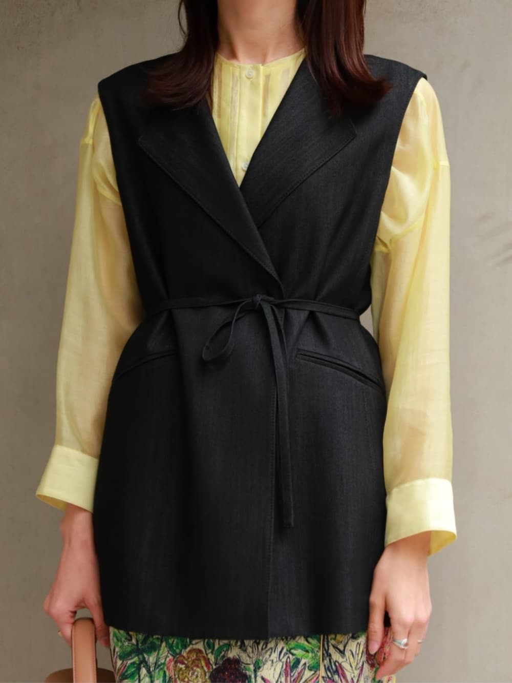 イエロー系のシャツ/ブラウス、ブラック系のベスト、グリーン系のスカートを着用したレディースの春コーディネートの2枚目の写真