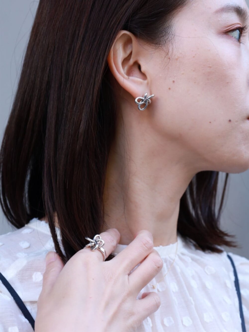 ホワイト系のカーディガン/ボレロ、ホワイト系のシャツ/ブラウス、ブルー系のワンピースを着用したレディースの冬コーディネートの3枚目の写真