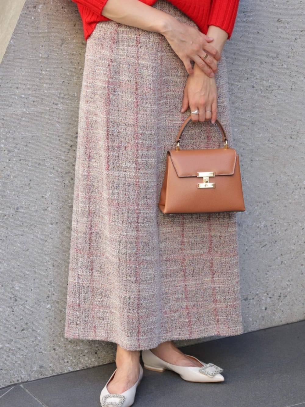 レッド系のニット/セーター、イエロー系のハンドバッグ、ベージュ系のその他シューズを着用したレディースの秋コーディネートの3枚目の写真