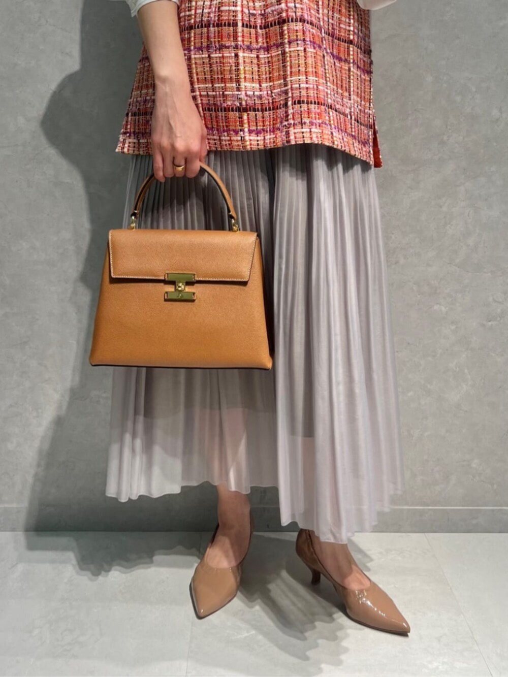 ベージュ系のスカート、ホワイト系のシャツ/ブラウス、ピンク系のベストを着用したレディースの春コーディネートの3枚目の写真