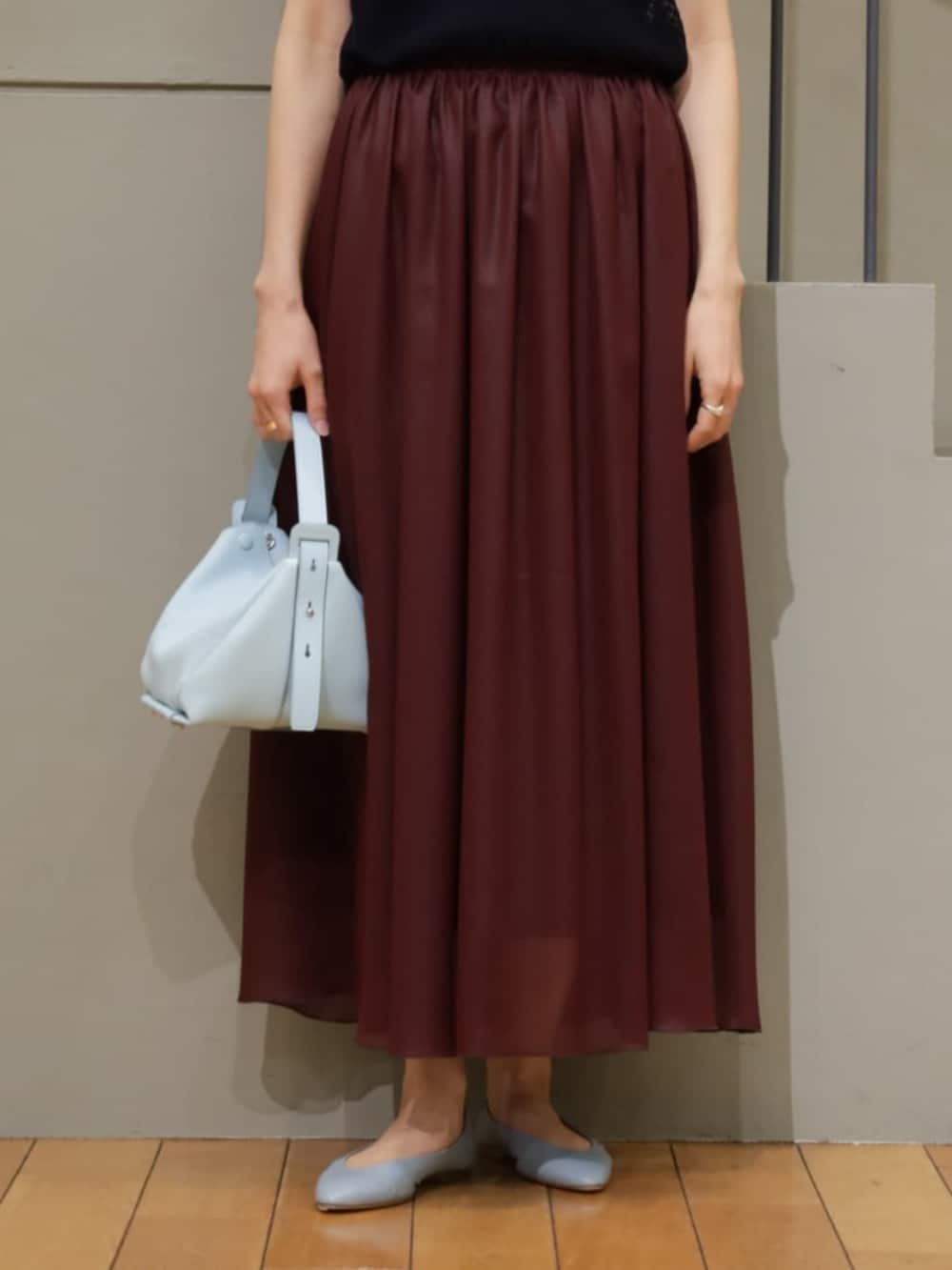 ブルー系のカーディガン/ボレロ、ブルー系のニット/セーター、レッド系のスカートを着用したレディースの夏コーディネートの4枚目の写真