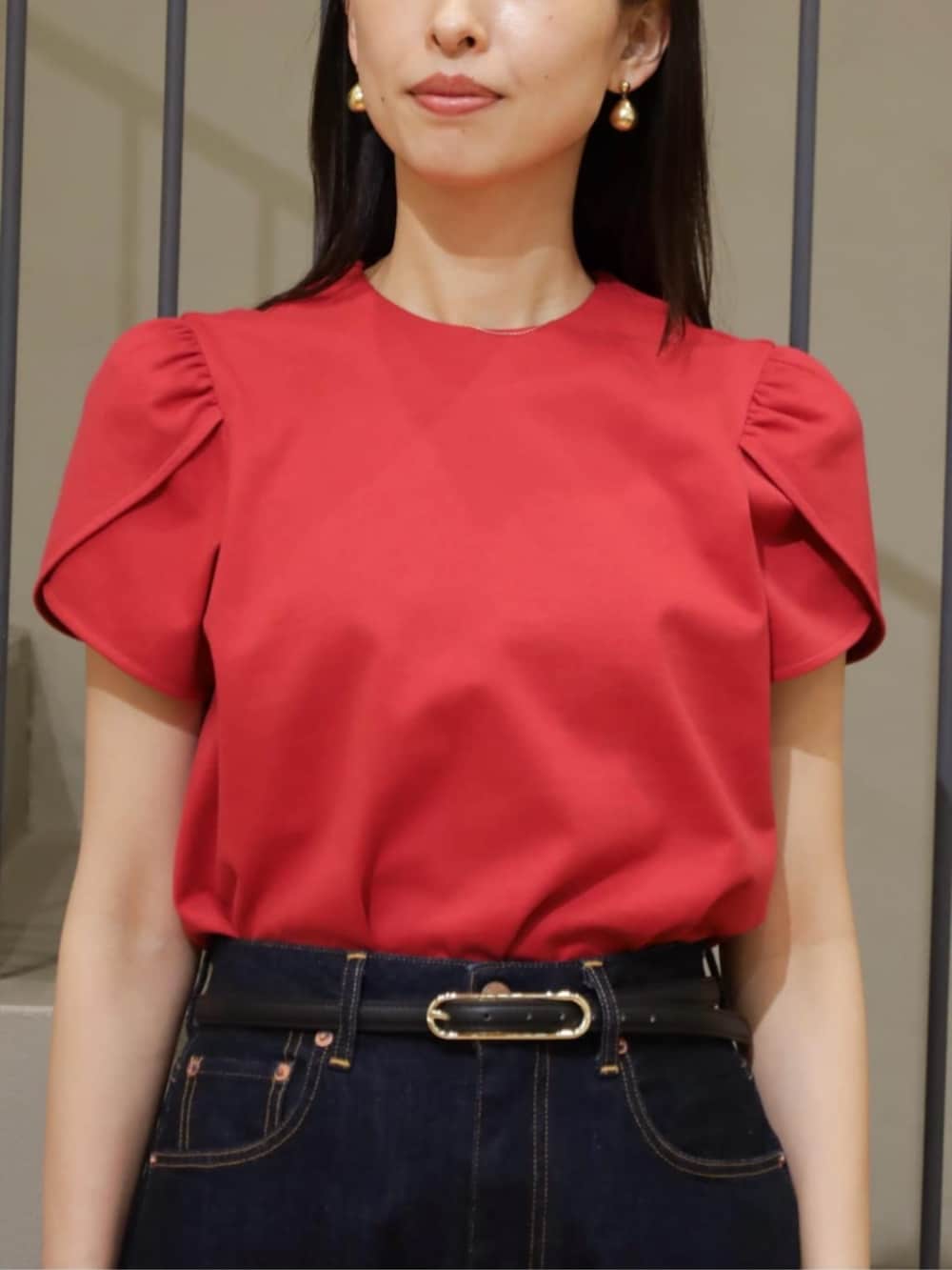 レッド系のTシャツ/カットソー、ブルー系のデニムパンツ、ブラック系のかごバッグを着用したレディースの春コーディネートの2枚目の写真