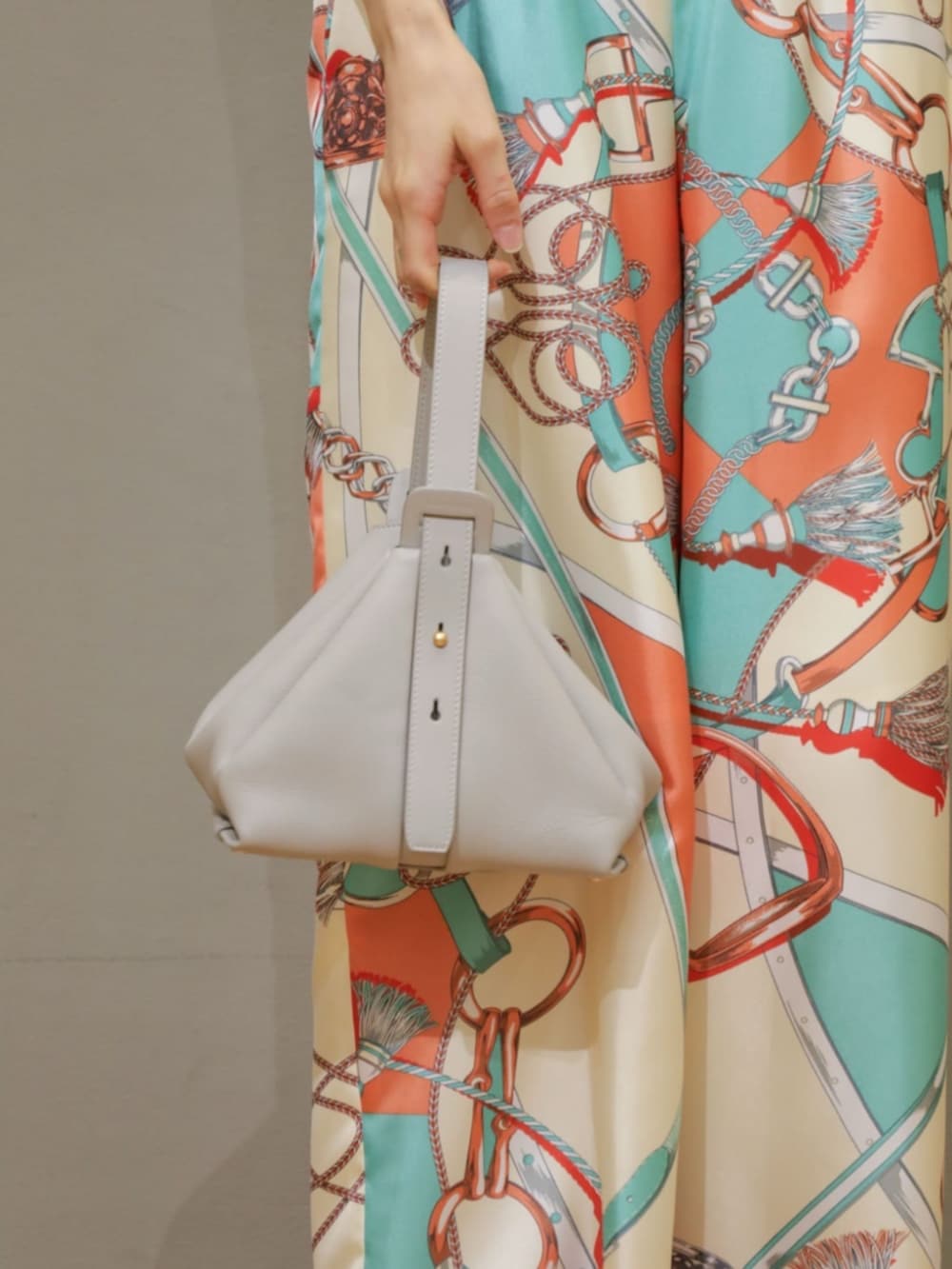 グリーン系のカーディガン/ボレロ、グリーン系のニット/セーター、グレー系のハンドバッグを着用したレディースの春コーディネートの5枚目の写真