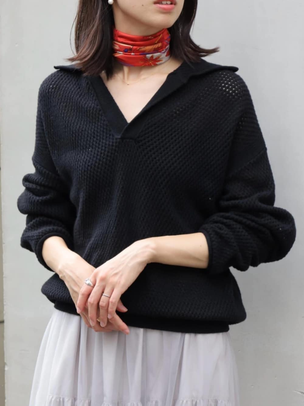 ブラック系のニット/セーター、グレー系のスカート、ホワイト系のピアス（両耳用）を着用したレディースの秋コーディネートの2枚目の写真