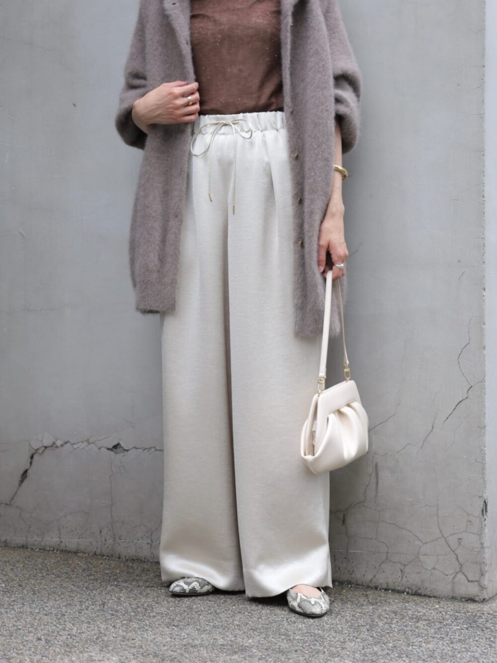 ベージュ系のその他アウター、グレー系のニット/セーター、ホワイト系のクラッチバッグを着用したレディースの秋コーディネートの4枚目の写真