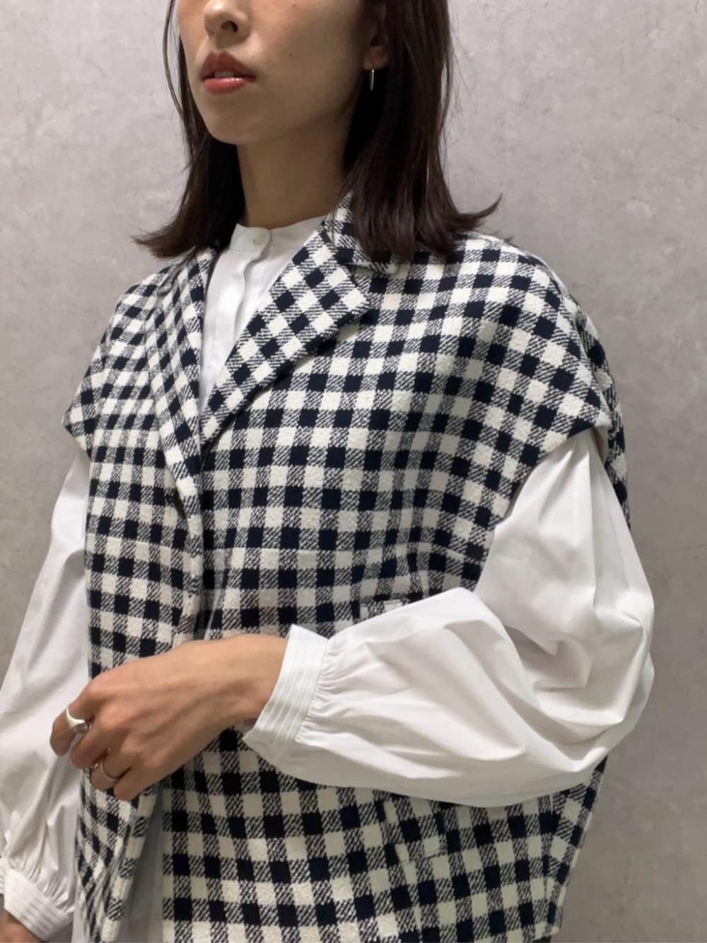 ブルー系のベスト、ホワイト系のシャツ/ブラウス、ブルー系のデニムパンツを着用したレディースの冬コーディネートの2枚目の写真