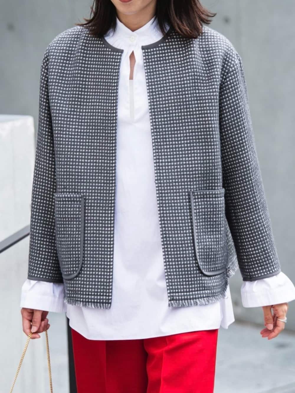 グレー系のノーカラージャケット、ホワイト系のシャツ/ブラウス、レッド系のスラックスを着用したレディースの秋コーディネートの2枚目の写真